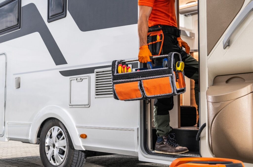 Wohnmobiltechniker beim Betreten eines Wohnmobils mit Werkzeugkasten